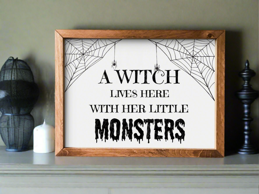 A witch lives here with her little monsters sign. Halloween wall decor.